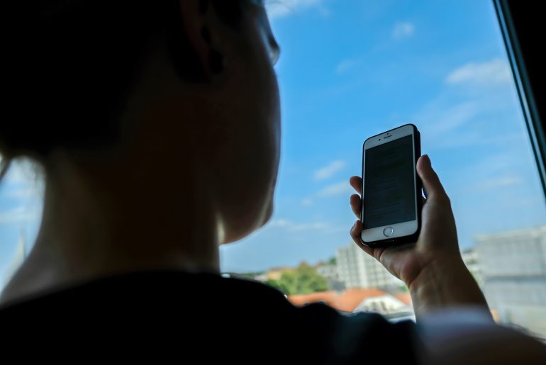 Eine Frau schaut auf ihr Handy (Symbolbild). Eine Brazilian-Jiu-Jitsu-Kämpferin aus Oldenburg hat von einem hochrangigen Ausbilder, einem sogenannten Blackbelt, anzügliche Nachrichten erhalten. Bild: Christian J. Ahlers